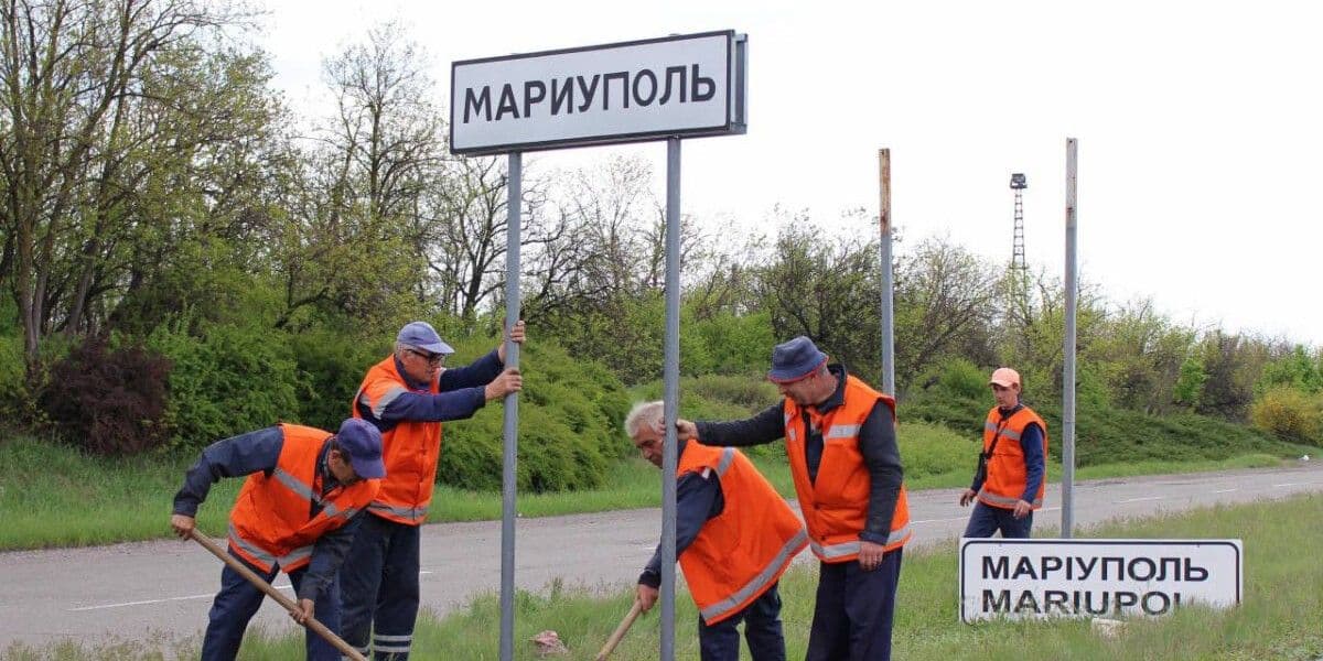 <em>Заміна дорожнього знаку в окупованому Маріуполі. Фото: АрміяInform</em>
