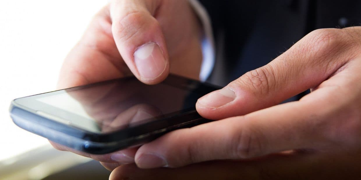 Смартфон у руках. Фото: Freepik