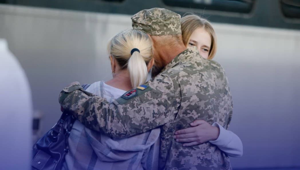 військовий з родиною біля вагону