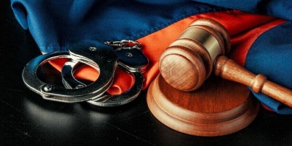 Кайданки, суддівський молоток і прапор України. Фото: ЦПД